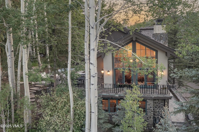 416 Forest Rd Unit A, Vail, CO 81657 - rear view of property featuring a chimney, stucco siding, and stone siding