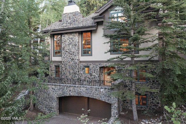 416 Forest Rd Unit A, Vail, CO 81657 - view of front facade with stone siding, stucco siding, and a chimney