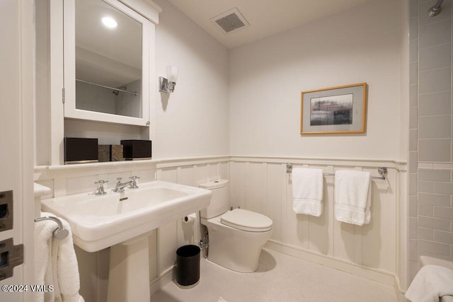 bathroom featuring toilet, sink, and walk in shower