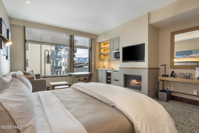 bedroom featuring beverage cooler and a tile fireplace