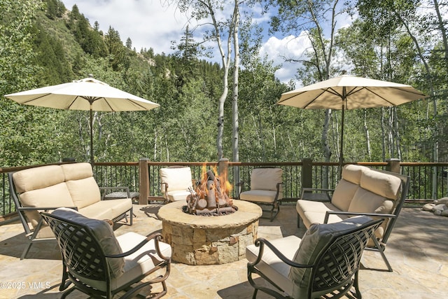 179 S Fairway Dr, Beaver Creek, CO 81620 - view of patio with an outdoor living space with a fire pit and a view of trees