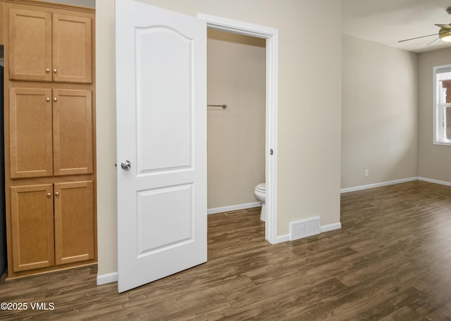 unfurnished bedroom with baseboards, visible vents, and dark wood-type flooring