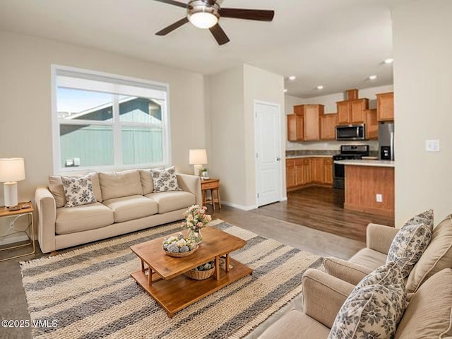 living room featuring baseboards, a ceiling fan, light wood-style flooring, and recessed lighting