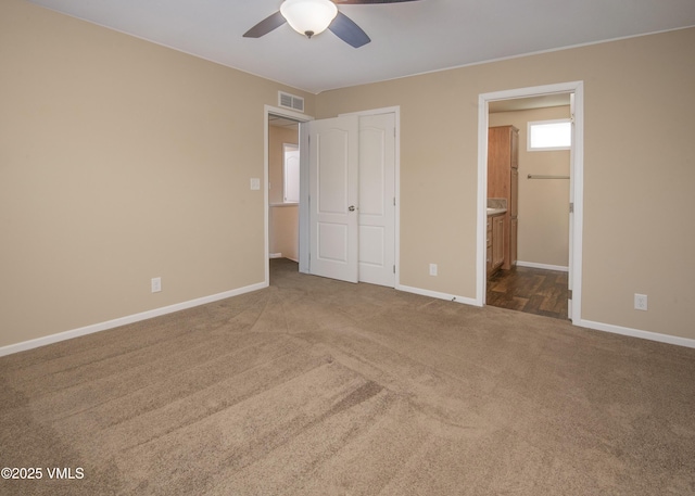 unfurnished bedroom with baseboards, carpet, connected bathroom, and visible vents