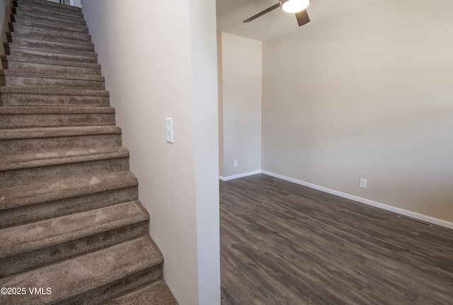 staircase featuring ceiling fan, baseboards, visible vents, and wood finished floors