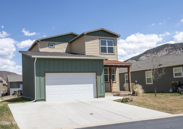 view of front facade with a garage, roof with shingles, board and batten siding, a mountain view, and driveway