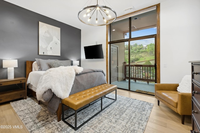 295 Main St Unit R305, Edwards, CO 81632 - bedroom featuring a chandelier, access to exterior, and light wood-style floors