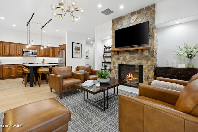 295 Main St Unit R305, Edwards, CO 81632 - living area featuring light wood-type flooring, a stone fireplace, and a chandelier