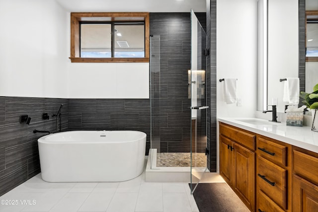 295 Main St Unit R305, Edwards, CO 81632 - full bathroom featuring tile walls, vanity, a soaking tub, a stall shower, and a wainscoted wall