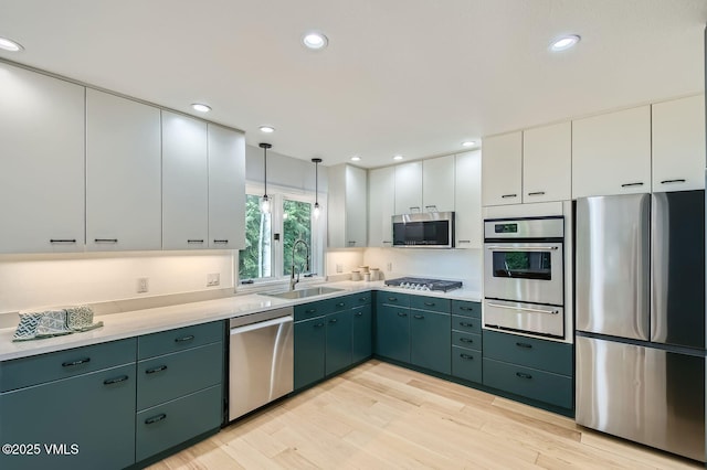1359 Greenhill Ct Unit E, Vail, CO 81657 - kitchen with stainless steel appliances, a warming drawer, light countertops, white cabinets, and light wood finished floors