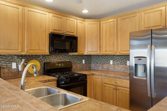 kitchen with a sink, decorative backsplash, black appliances, and light brown cabinetry