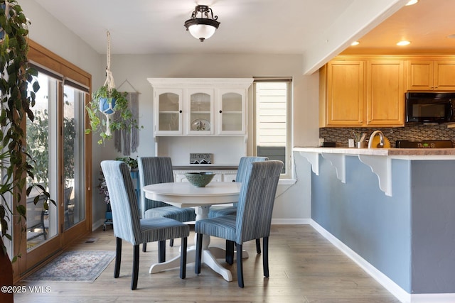 dining area with recessed lighting, baseboards, and light wood finished floors