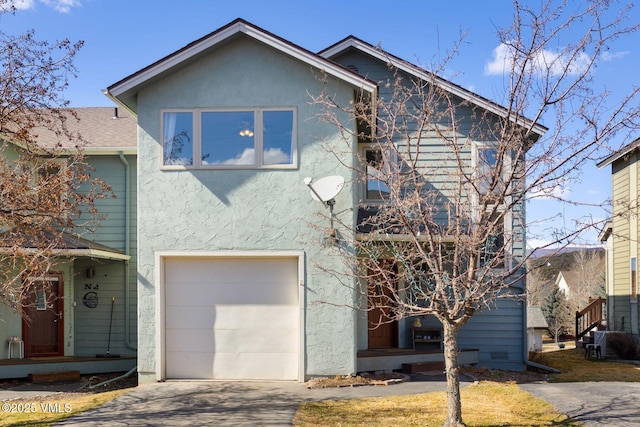 view of front of house with stucco siding, concrete driveway, and an attached garage