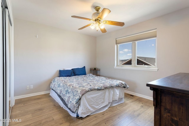 bedroom featuring light wood-style floors, baseboards, and ceiling fan