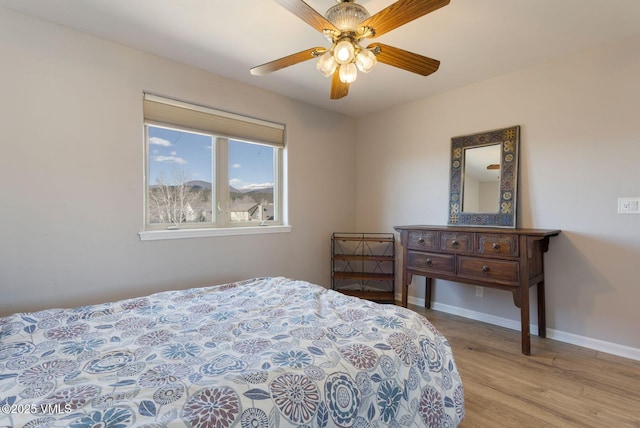 bedroom featuring light wood finished floors, ceiling fan, and baseboards