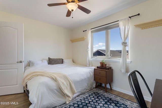 bedroom with a ceiling fan, baseboards, and wood finished floors