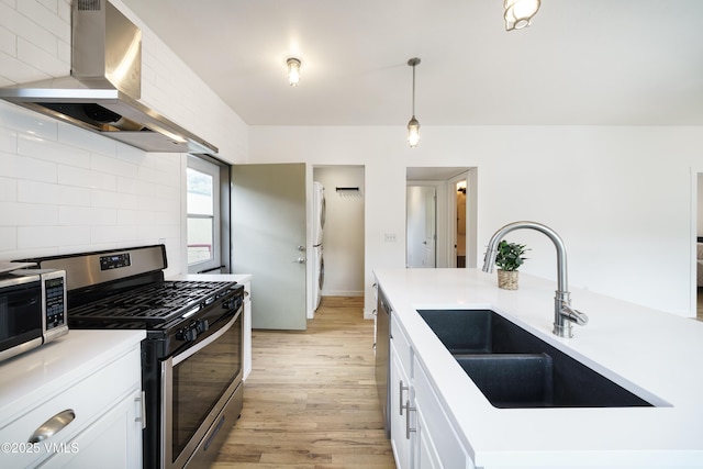 511 Metcalf Unit J30, Avon, CO 81620 - kitchen with stainless steel appliances, a sink, wall chimney exhaust hood, light wood-style flooring, and tasteful backsplash