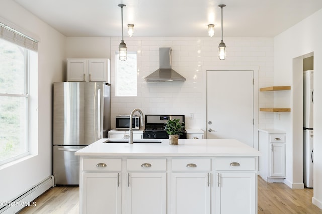 511 Metcalf Unit J30, Avon, CO 81620 - kitchen with wall chimney exhaust hood, appliances with stainless steel finishes, baseboard heating, open shelves, and plenty of natural light