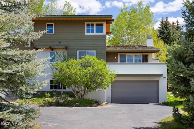 12 June Creek Rd, Edwards, CO 81632 - front of property featuring an attached garage, driveway, a chimney, and stucco siding