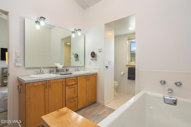 12 June Creek Rd, Edwards, CO 81632 - full bathroom with toilet, a tub to relax in, double vanity, wood finished floors, and baseboards