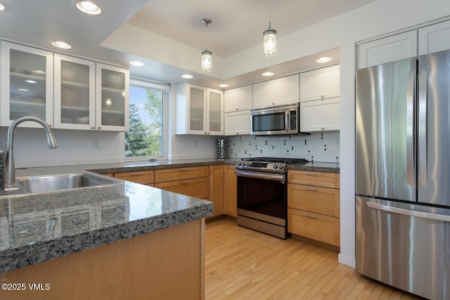 12 June Creek Rd, Edwards, CO 81632 - kitchen featuring stainless steel appliances, a sink, pendant lighting, light wood-type flooring, and glass insert cabinets