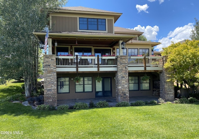 rear view of house featuring a lawn and board and batten siding