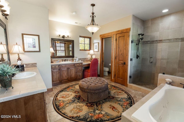 bathroom featuring a tub with jets, two vanities, a sink, a shower stall, and tile patterned floors