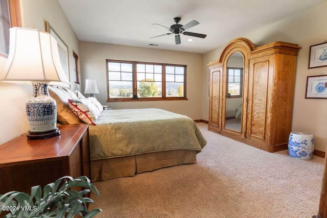 carpeted bedroom featuring visible vents, baseboards, and ceiling fan