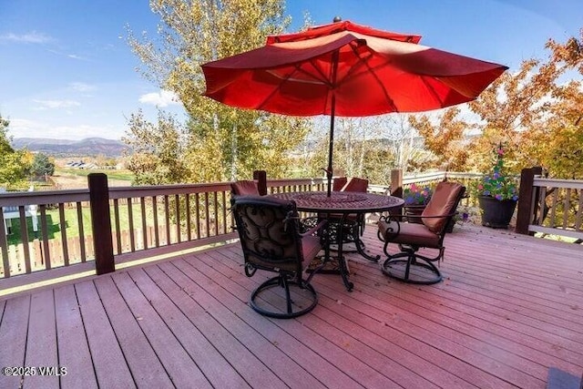 deck featuring outdoor dining area and a mountain view