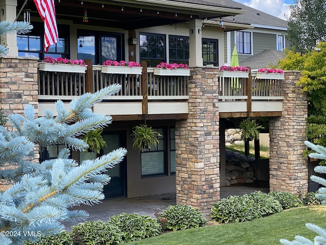 rear view of property featuring a balcony and roof with shingles