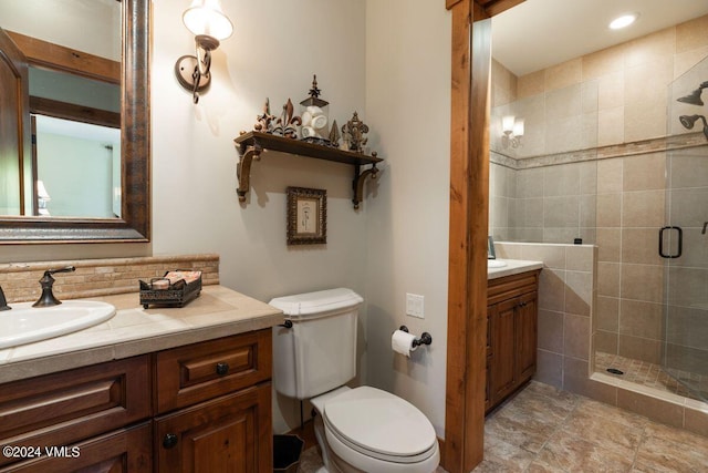 bathroom with vanity, a shower stall, and toilet