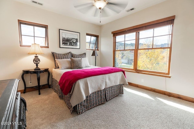 carpeted bedroom with visible vents, baseboards, and a ceiling fan