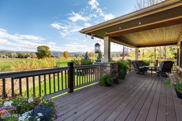 wooden deck featuring a lawn and a mountain view