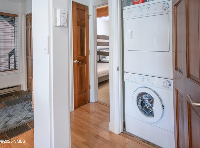 4479 Timber Falls Ct Unit 2001, Vail, CO 81657 - laundry area featuring stacked washer / dryer, light wood-type flooring, and a baseboard radiator