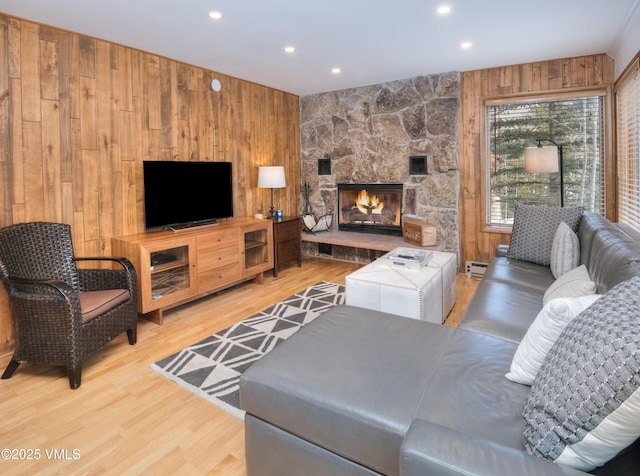 4479 Timber Falls Ct Unit 2001, Vail, CO 81657 - living room featuring wooden walls, wood finished floors, a stone fireplace, baseboard heating, and recessed lighting