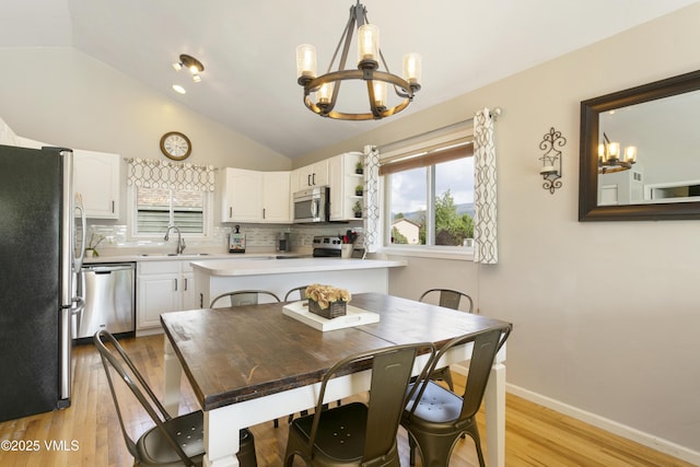 443 Porphyry Rd Unit F, Gypsum, CO 81637 - dining room with a chandelier, lofted ceiling, light wood-type flooring, and baseboards