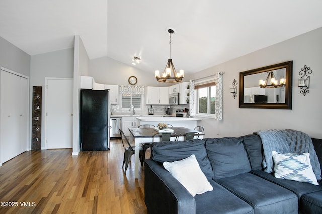 443 Porphyry Rd Unit F, Gypsum, CO 81637 - living room with a chandelier, light wood-type flooring, and high vaulted ceiling