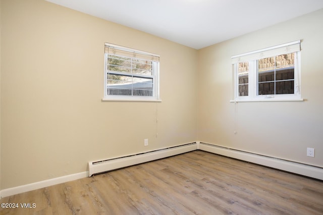 unfurnished room featuring light hardwood / wood-style flooring and baseboard heating