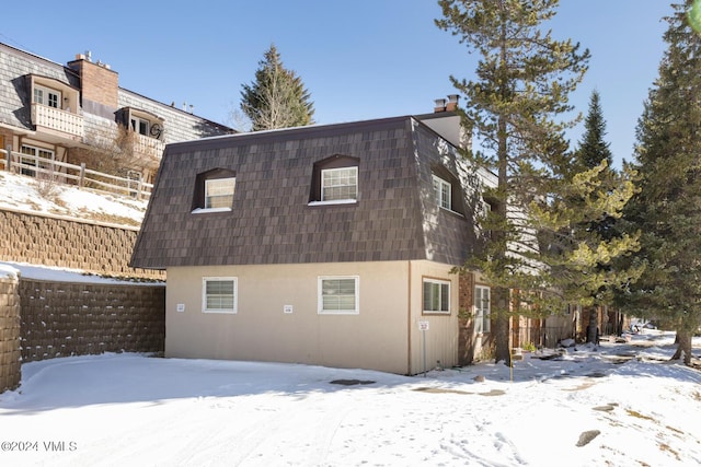 view of snow covered rear of property