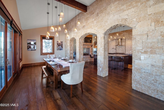 dining room with a multi sided fireplace, dark hardwood / wood-style floors, high vaulted ceiling, and beam ceiling