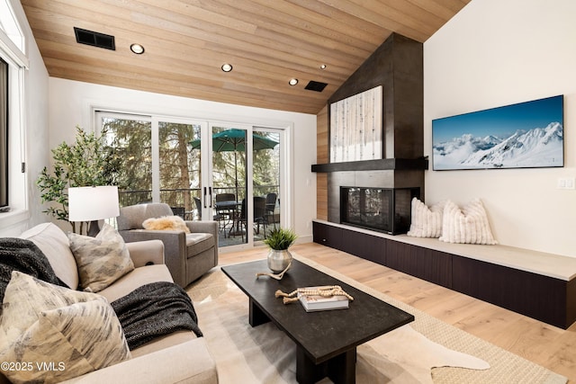 living area featuring vaulted ceiling, recessed lighting, wood ceiling, and a multi sided fireplace