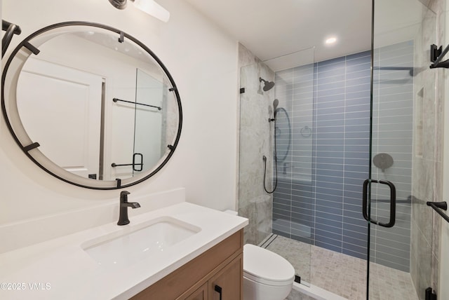 bathroom with recessed lighting, vanity, toilet, and a shower stall