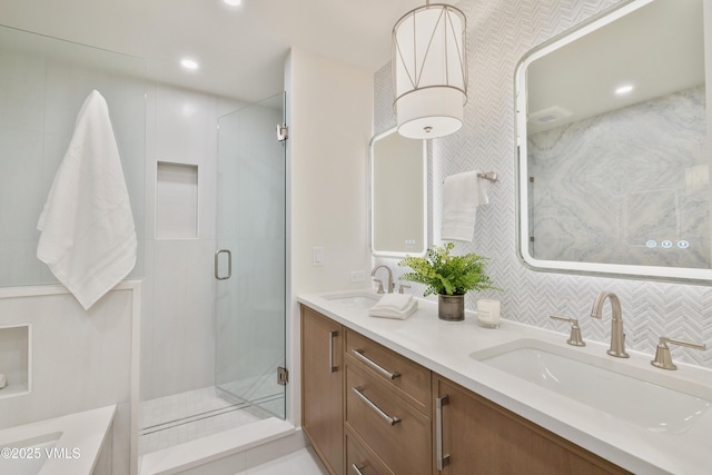 full bath featuring a shower stall, recessed lighting, double vanity, and a sink