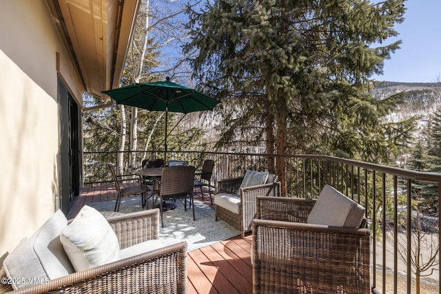 wooden terrace featuring outdoor dining area and an outdoor hangout area