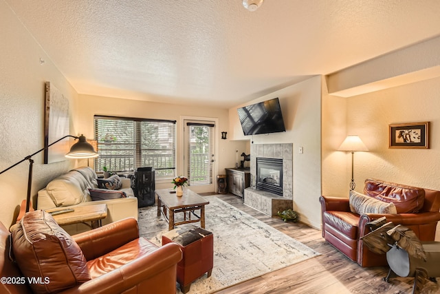 55 River Pines Ct Unit A204, Edwards, CO 81632 - living area with a textured wall, wood finished floors, a textured ceiling, and a fireplace