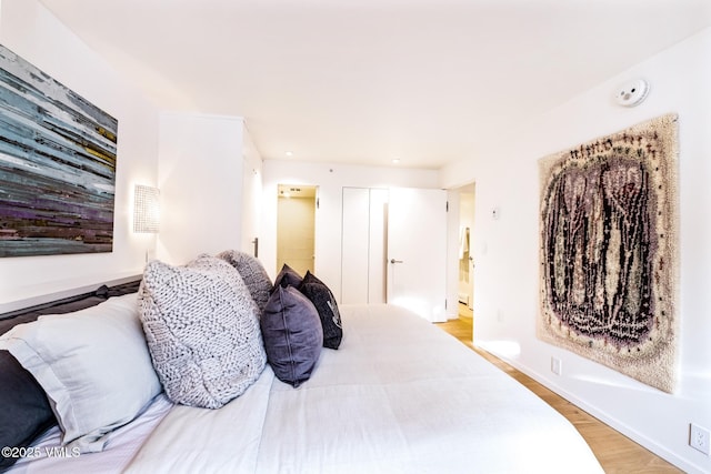 bedroom featuring light hardwood / wood-style flooring and ensuite bathroom