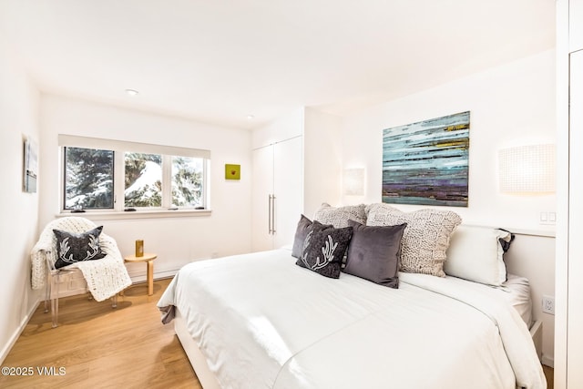 bedroom with a closet and light hardwood / wood-style flooring