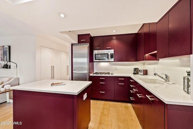 kitchen featuring light hardwood / wood-style floors, stainless steel appliances, a center island, and sink