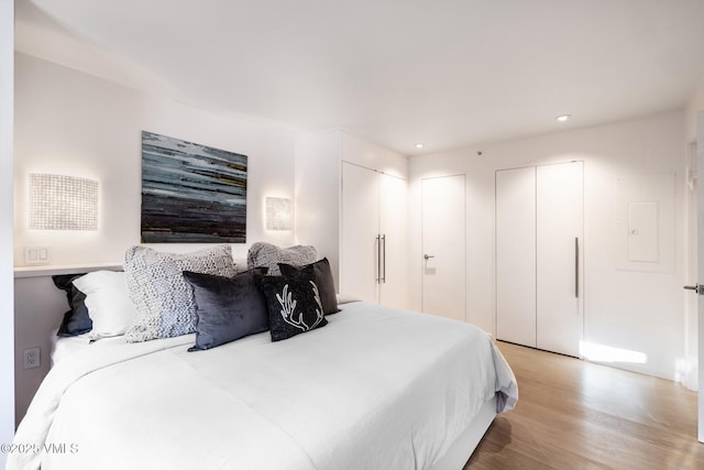 bedroom with two closets and light wood-type flooring