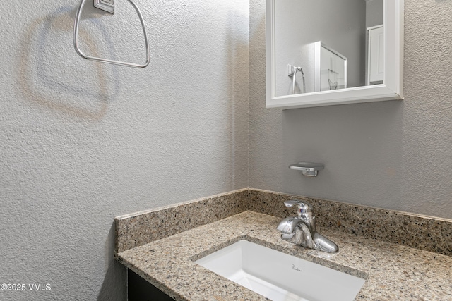 bathroom with vanity and a textured wall